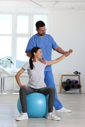 Photo of Physiotherapist working with patient in rehabilitation center