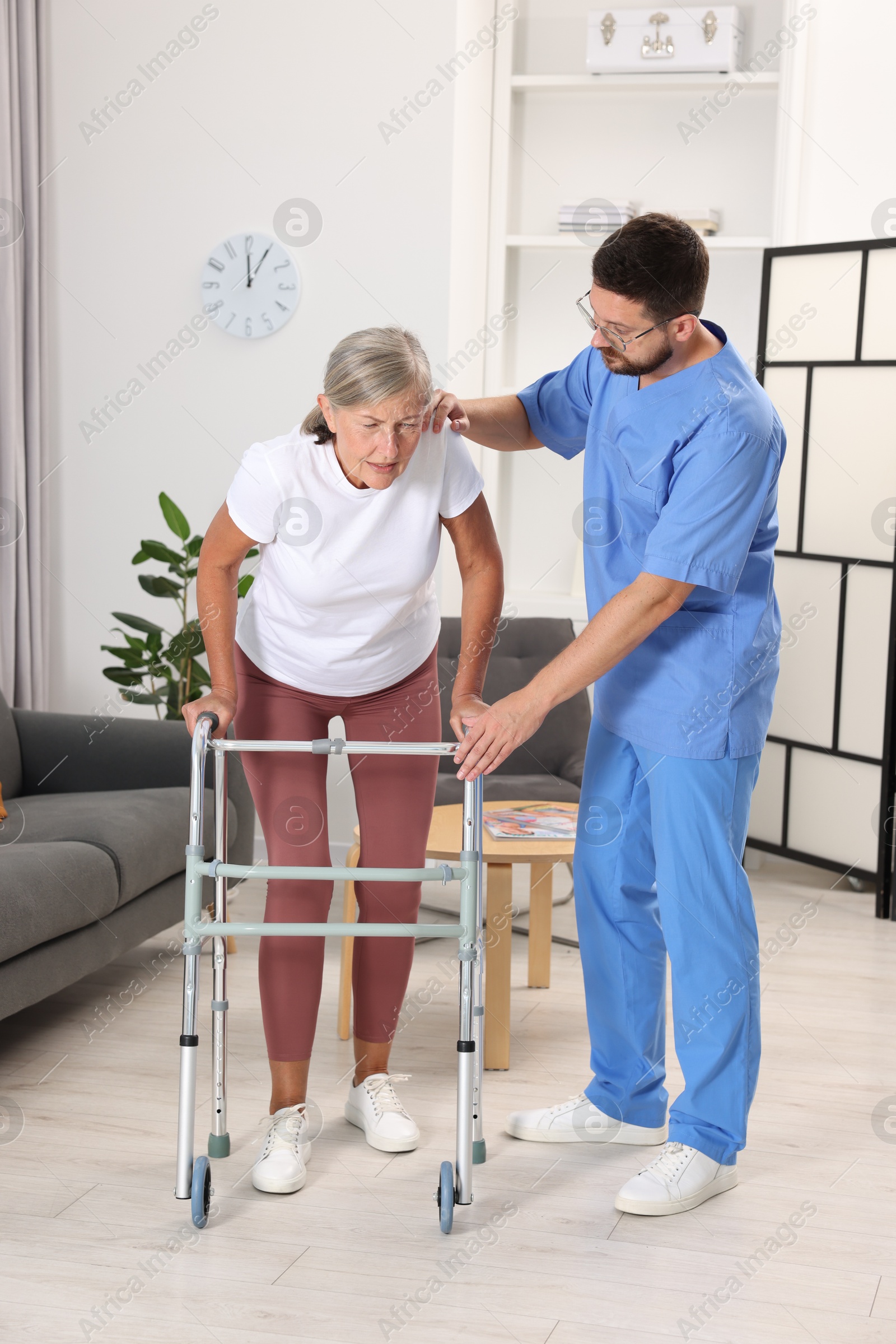 Photo of Rehabilitation. Physiotherapist working with senior patient indoors