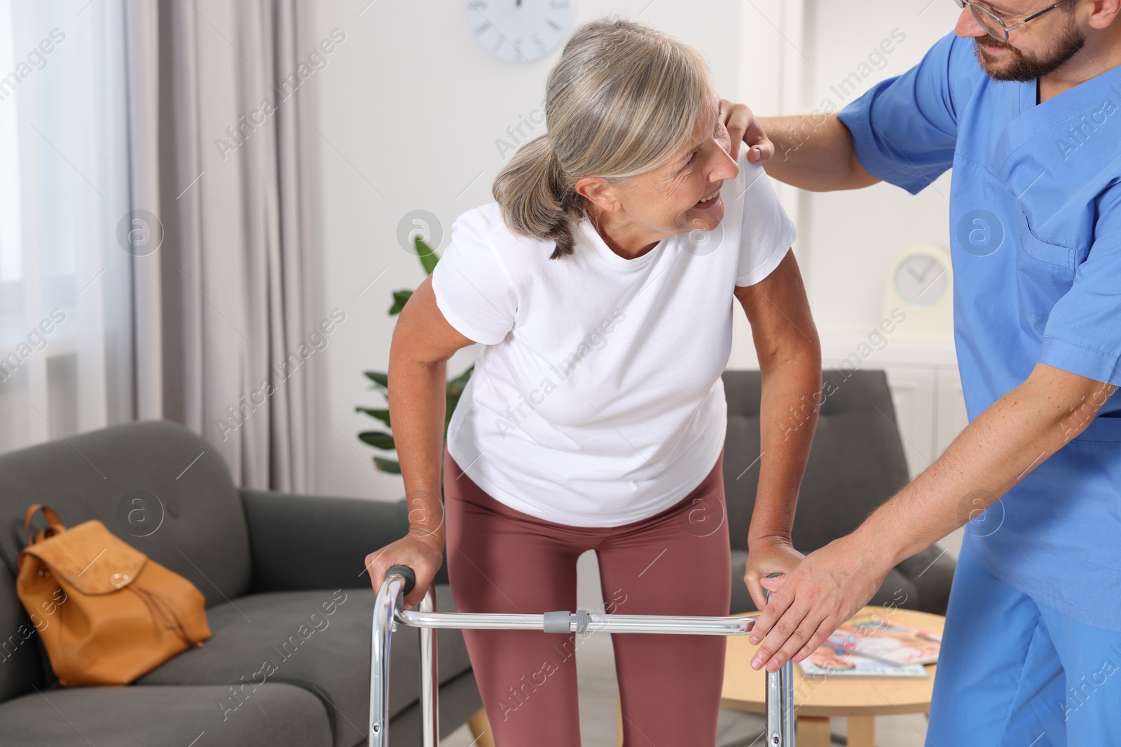 Photo of Rehabilitation. Physiotherapist working with senior patient indoors