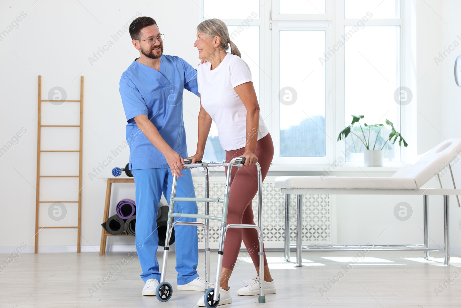 Photo of Physiotherapist working with senior patient in rehabilitation center