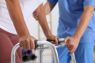 Physiotherapist working with senior patient in rehabilitation center, closeup