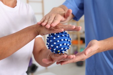 Photo of Physiotherapist working with senior patient in rehabilitation center, closeup