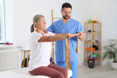 Photo of Senior patient exercising under physiotherapist supervision in rehabilitation center