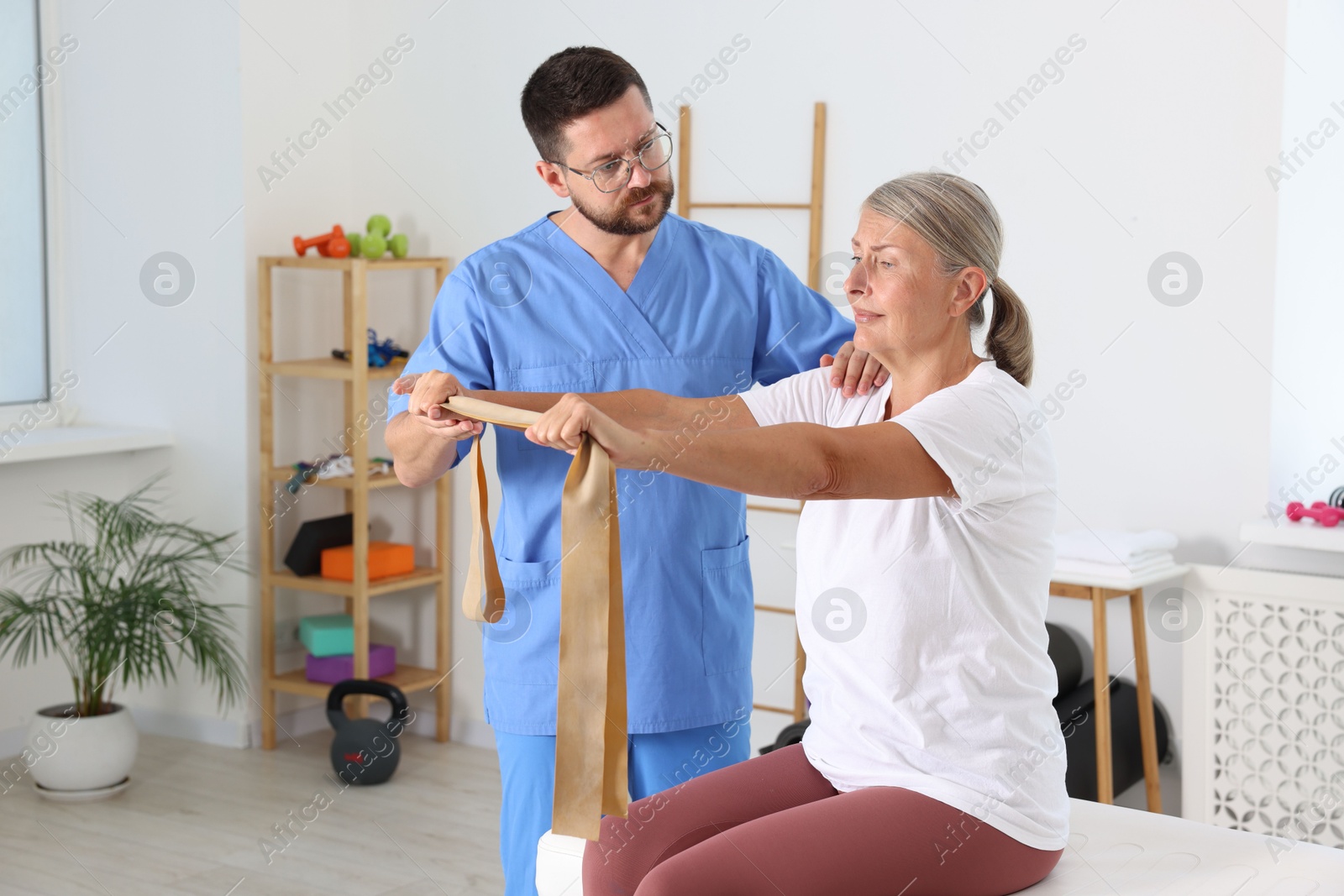 Photo of Senior patient exercising under physiotherapist supervision in rehabilitation center