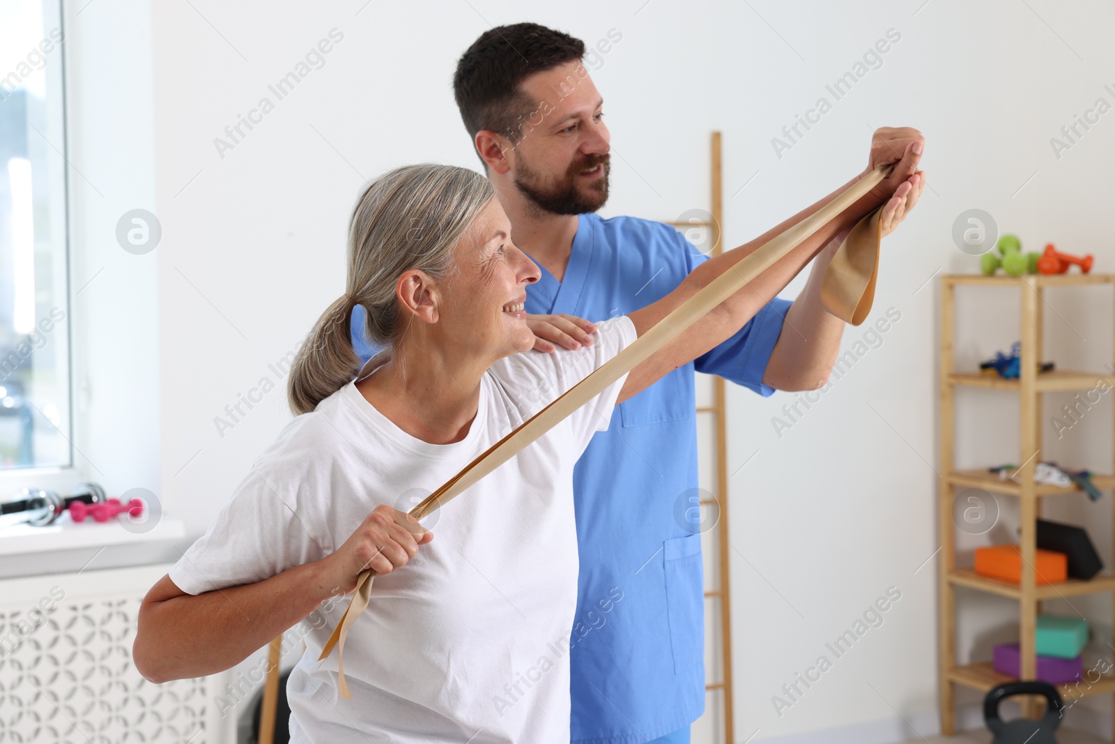 Photo of Senior patient exercising under physiotherapist supervision in rehabilitation center