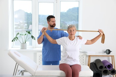 Photo of Senior patient exercising under physiotherapist supervision in rehabilitation center