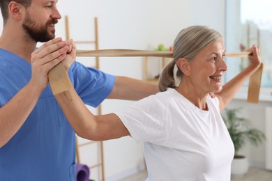 Senior patient exercising under physiotherapist supervision in rehabilitation center