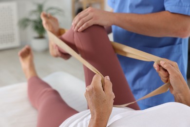 Photo of Physiotherapist working with senior patient in rehabilitation center, closeup