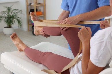 Physiotherapist working with senior patient in rehabilitation center, closeup