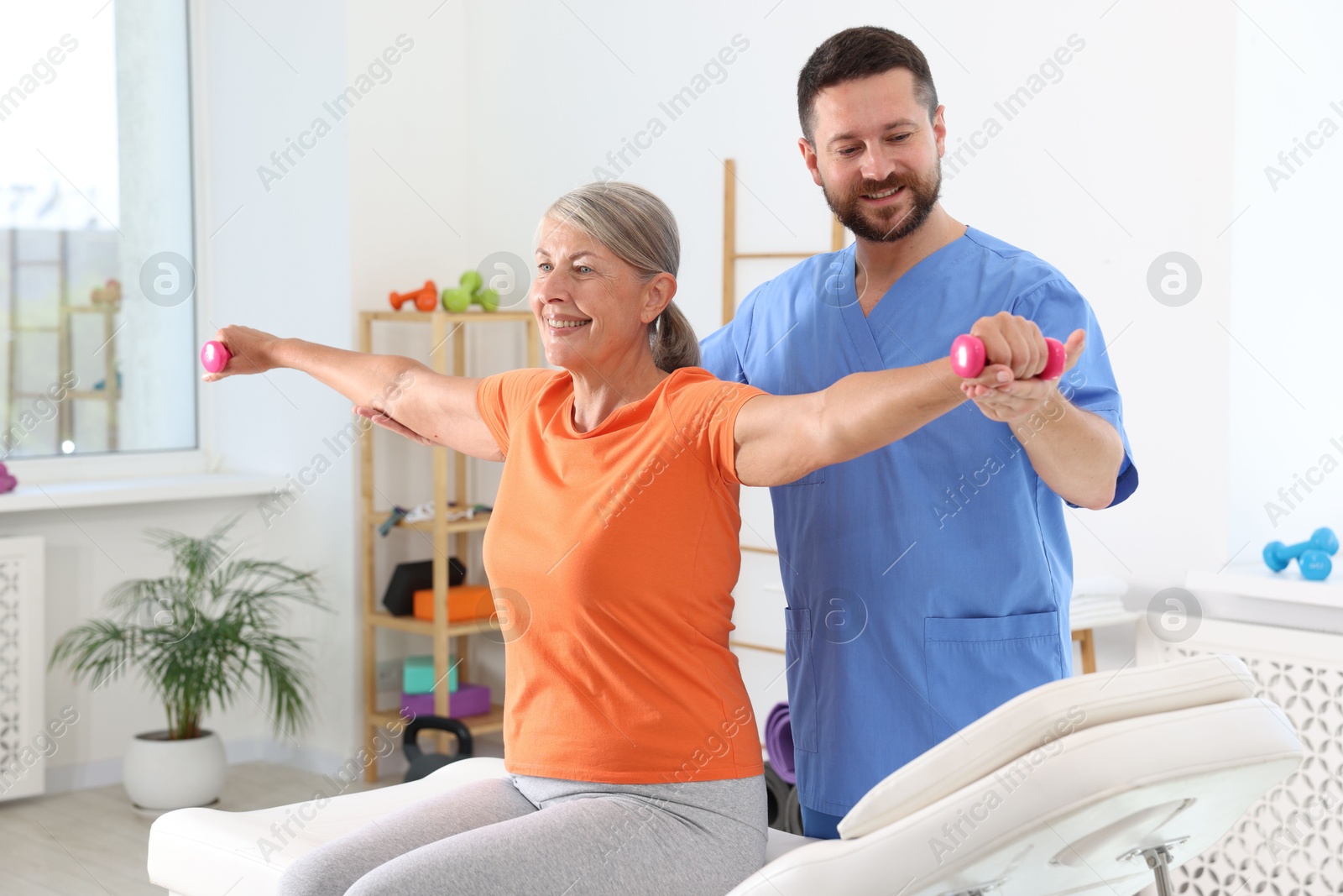 Photo of Senior patient exercising under physiotherapist supervision in rehabilitation center