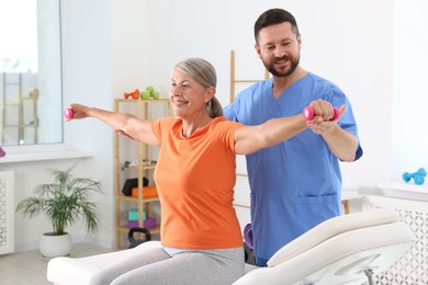 Senior patient exercising under physiotherapist supervision in rehabilitation center