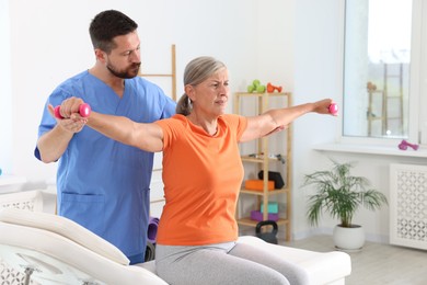 Photo of Senior patient exercising under physiotherapist supervision in rehabilitation center