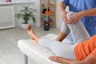 Physiotherapist working with senior patient in rehabilitation center, closeup