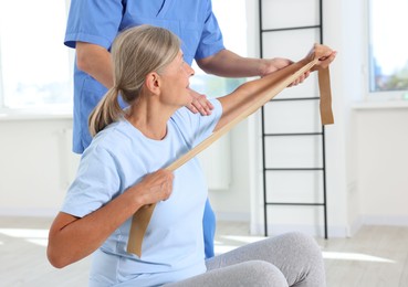 Senior patient exercising under physiotherapist supervision in rehabilitation center