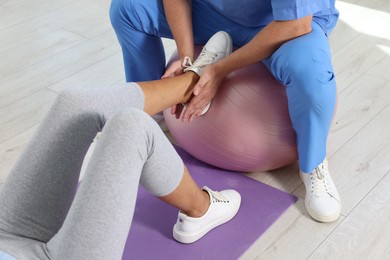 Physiotherapist working with senior patient in rehabilitation center, closeup