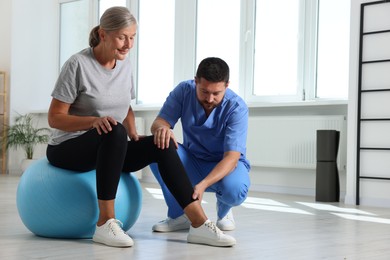 Physiotherapist working with senior patient in rehabilitation center