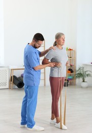 Senior patient exercising under physiotherapist supervision in rehabilitation center