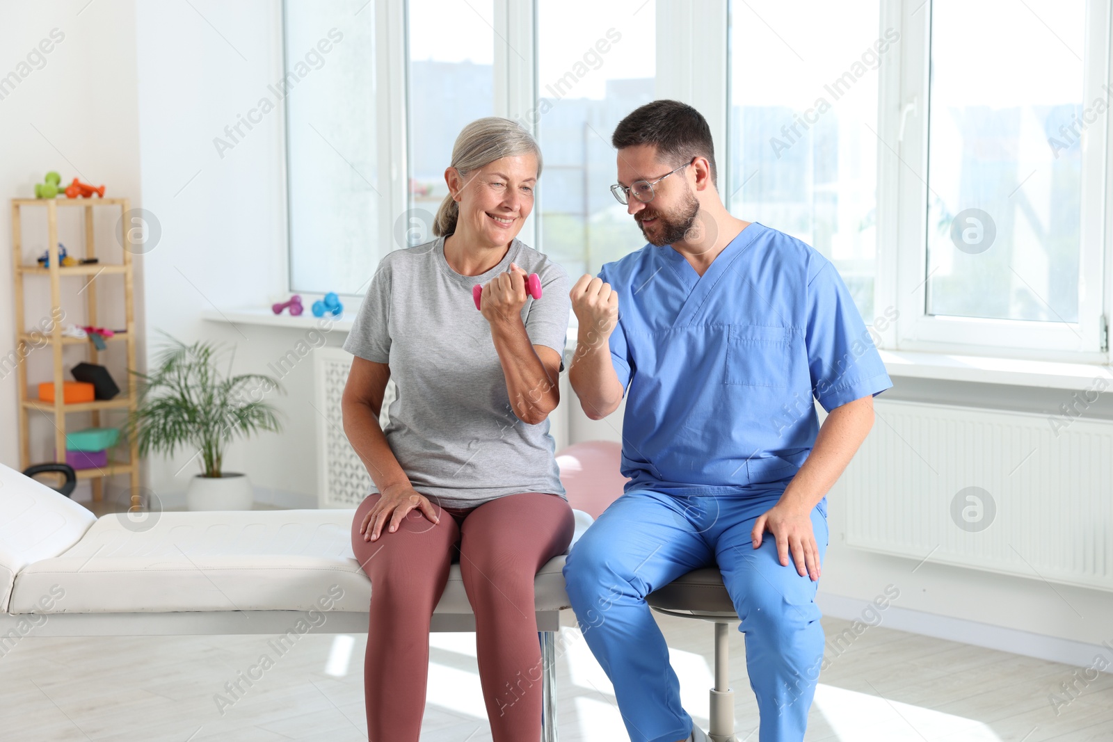 Photo of Senior patient exercising under physiotherapist supervision in rehabilitation center