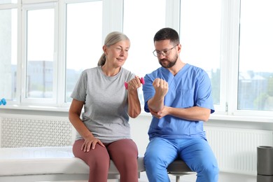 Senior patient exercising under physiotherapist supervision in rehabilitation center