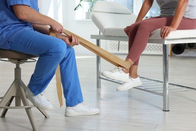 Photo of Physiotherapist working with senior patient in rehabilitation center, closeup