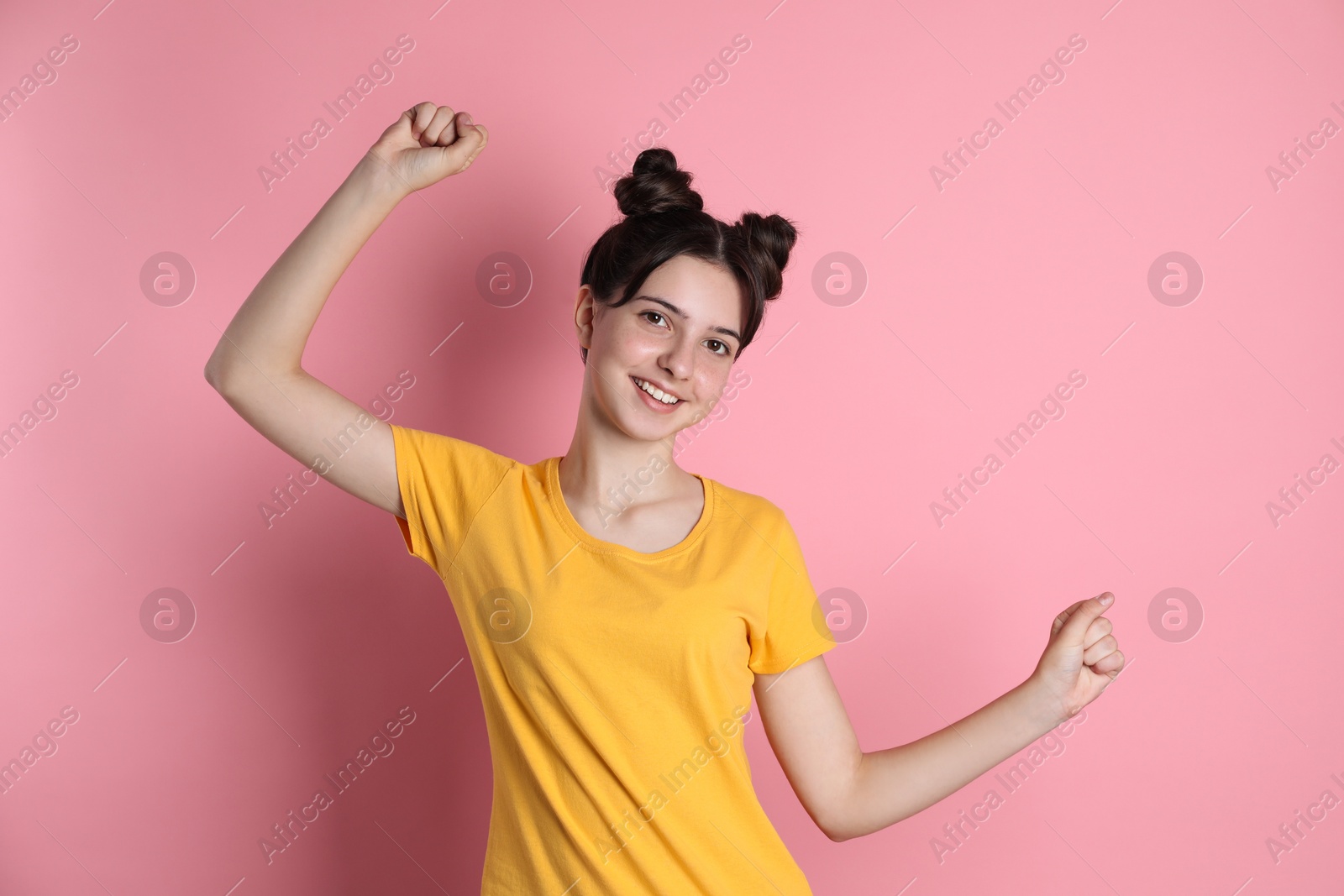 Photo of Portrait of smiling teenage girl on pink background