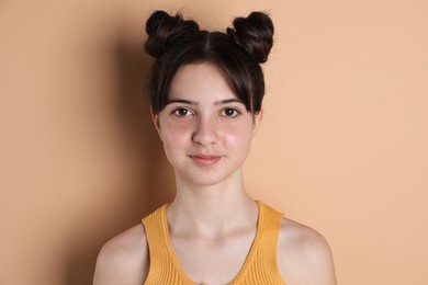 Portrait of cute teenage girl on beige background