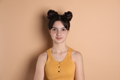 Portrait of cute teenage girl on beige background