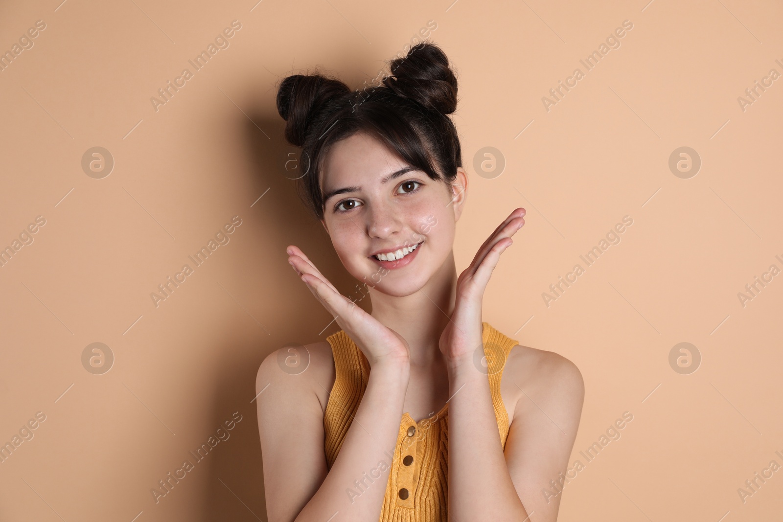 Photo of Portrait of smiling teenage girl on beige background