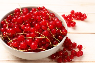 Photo of Fresh red currant berries in bowl on white wooden table, closeup