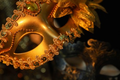 Beautiful golden carnival mask in darkness, closeup