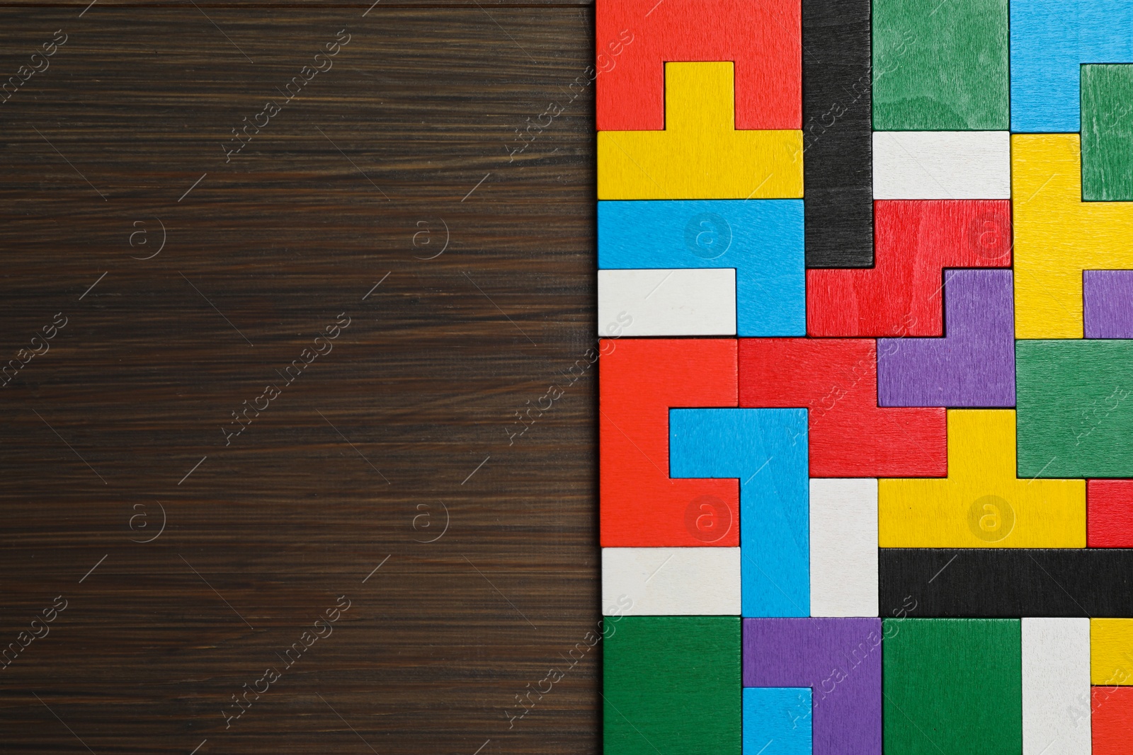 Photo of Colorful puzzle pieces on wooden table, top view. Space for text