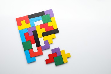 Photo of Colorful wooden puzzle pieces on white background, top view. Space for text