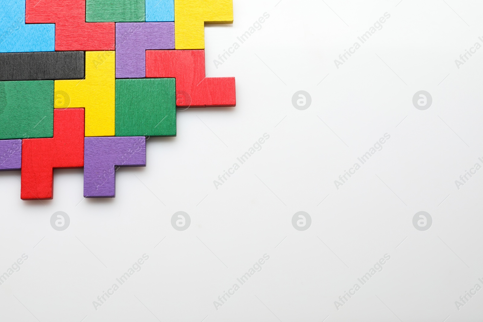 Photo of Colorful wooden puzzle pieces on white background, top view. Space for text