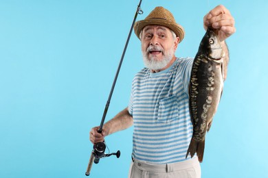 Photo of Fisherman with rod and catch on light blue background