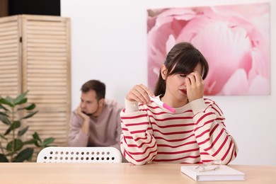 Worried young couple with pregnancy test at home