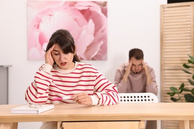 Photo of Worried young couple with pregnancy test at home