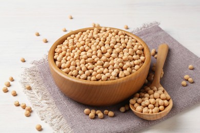 Dried peas in bowl on light wooden table, closeup