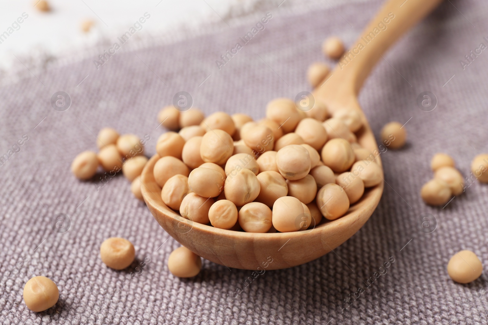 Photo of Spoon with dried peas on cloth, closeup