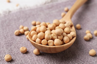 Spoon with dried peas on cloth, closeup