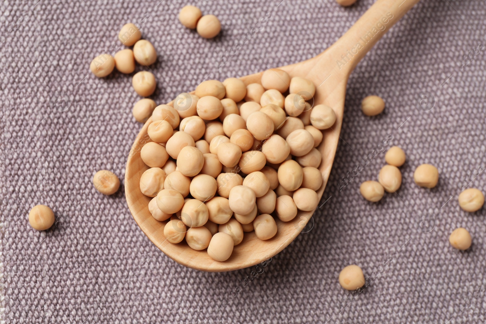 Photo of Spoon with dried peas on cloth, closeup