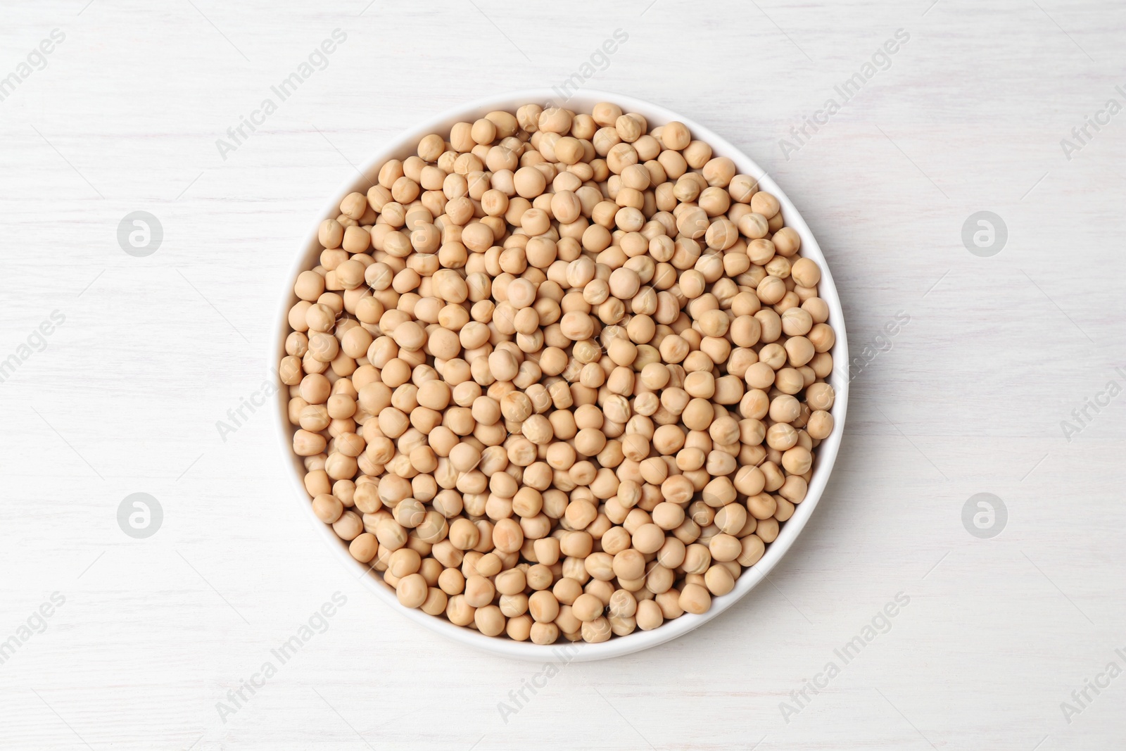 Photo of Dried peas on light wooden table, top view