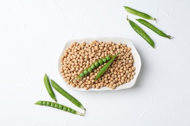 Dried peas and pods with fresh ones on white textured table, flat lay