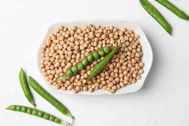 Dried peas and pods with fresh ones on white textured table, flat lay