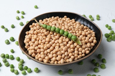 Dried peas and pod with fresh ones on white textured table, closeup