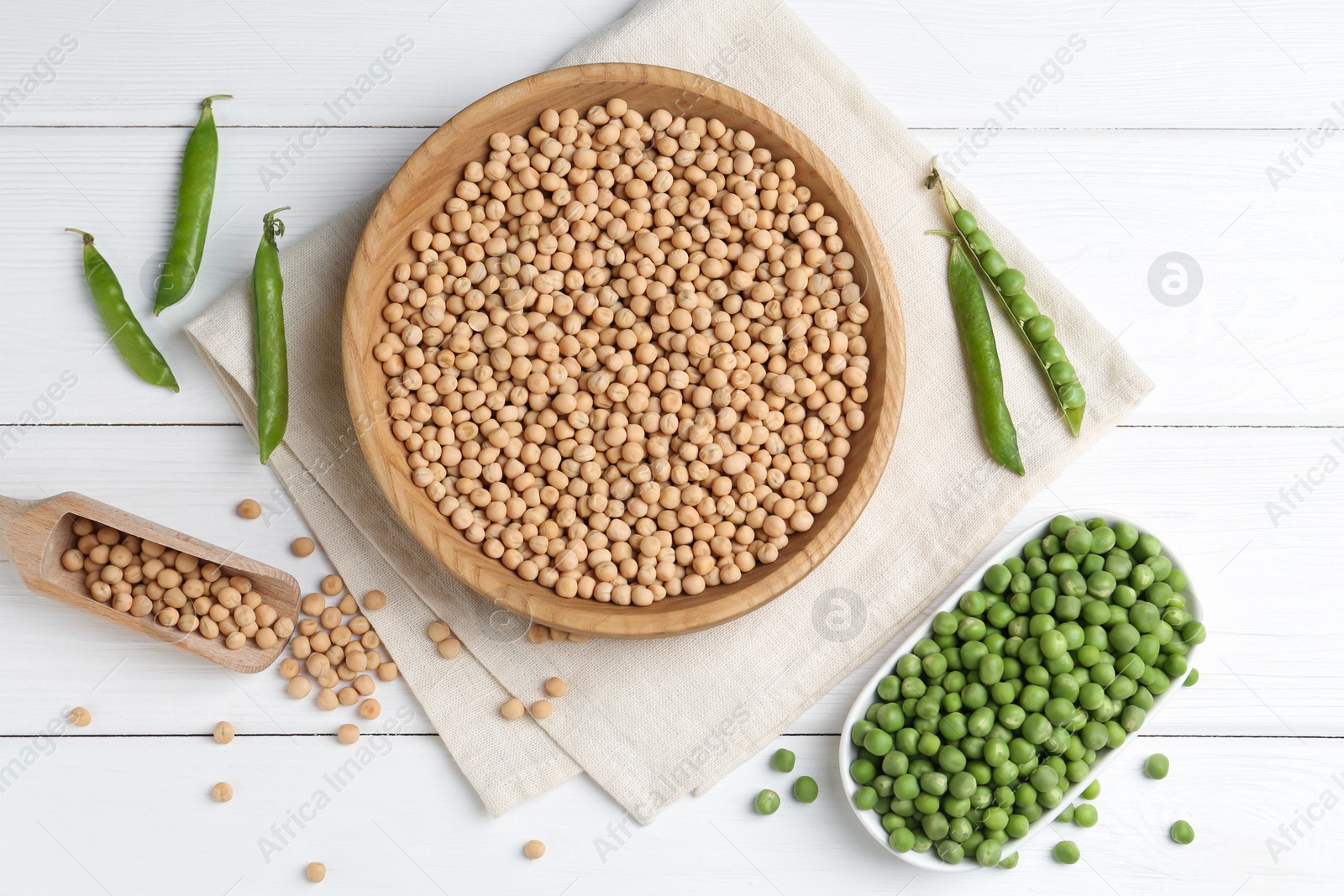 Photo of Dried peas and pods with fresh ones on white wooden table, flat lay