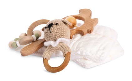 Photo of Wooden rattles and diapers isolated on white. Baby accessories