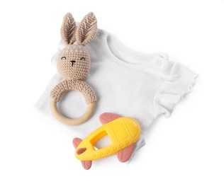 Photo of Colorful rattles and baby shirt isolated on white, top view