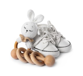 Photo of Wooden rattles and baby shoes isolated on white