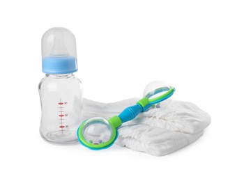 Photo of Baby rattle, bottle and diapers isolated on white