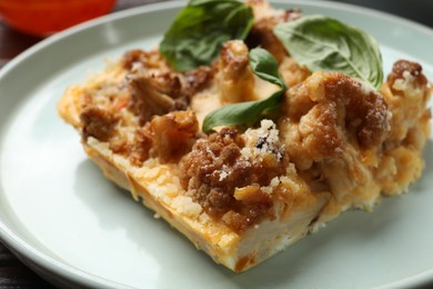 Photo of Tasty baked cauliflower and basil on plate, closeup